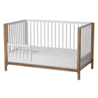 Solid New Zealand pine toddler guardrail with round spindles for converting the Laurel crib into a secure toddler bed.