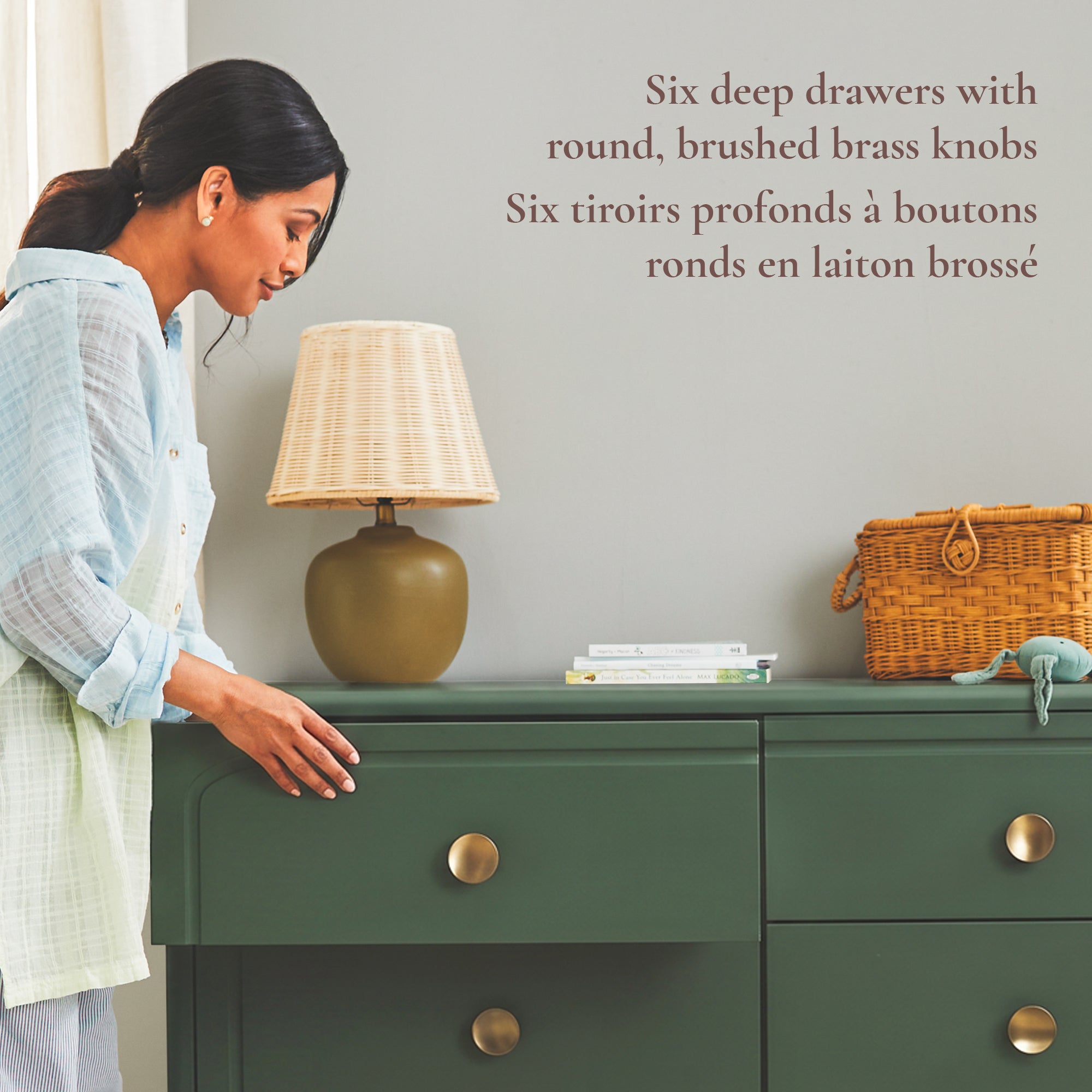 Lifestyle image of a mom opening the Briar nursery dresser, showcasing its six deep storage drawers with round, brushed brass knobs.