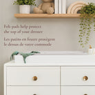 Lifestyle image highlighting the felt pads on the underside of the topper that protect the dresser surface.
