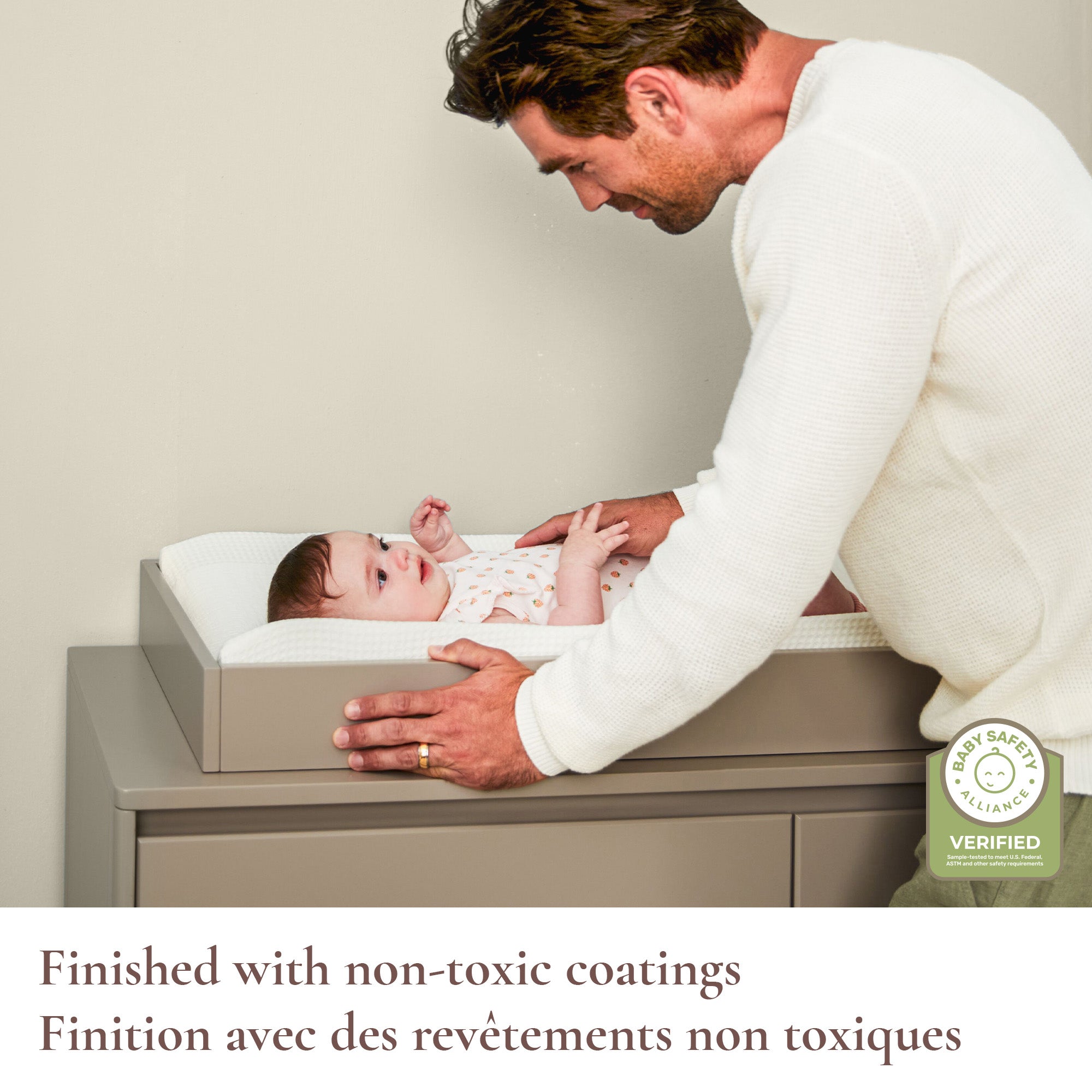 Lifestyle shot of a dad and baby featuring the non-toxic coating and Baby Safety Alliance verification.