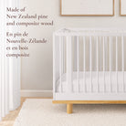 Close-up view of the Roo nursery crib showcasing its durable New Zealand pine and composite wood construction on a natural wood base.